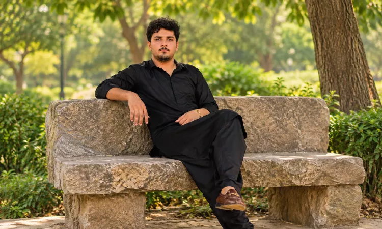 A Young Man Sitting On a Stone Bench Garden